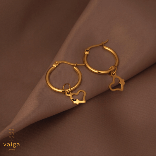 Gold-toned stainless steel hoop earrings with  by Vaiga Jewels, modern luxury women's accessory on blush pink background.