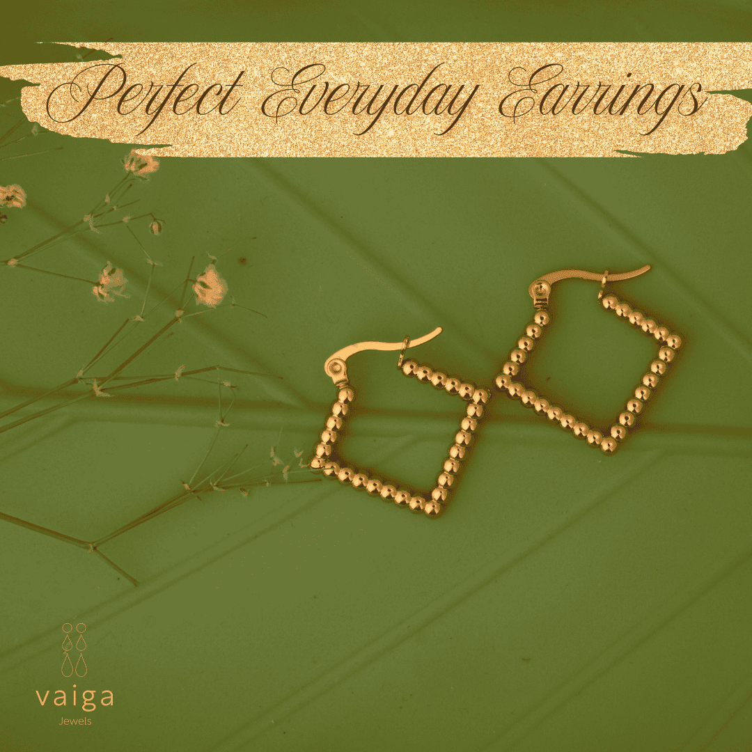 Gold-toned stainless steel  square-shaped earrings by Vaiga Jewels, modern luxury women's accessory on green, leaf textured background. Vaiga Jewels logo at the bottom left.