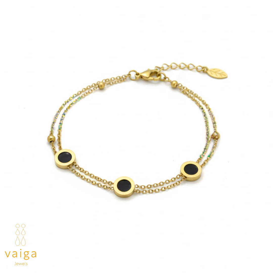 Gold bracelet with black stones on a white background, branded 'vaiga'.